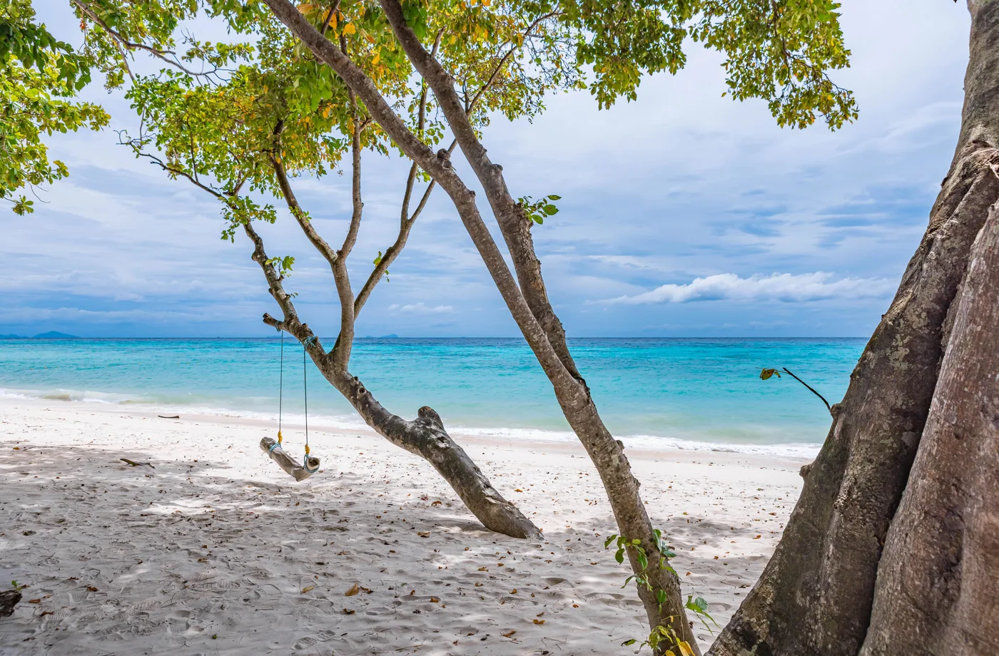 White beach and turquoise water beneath the trees on Rok Island