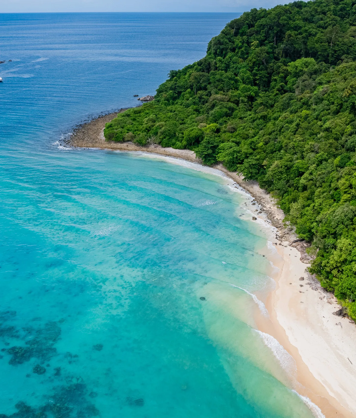 Rok Island's turquoise reef and forested coastline seen from above