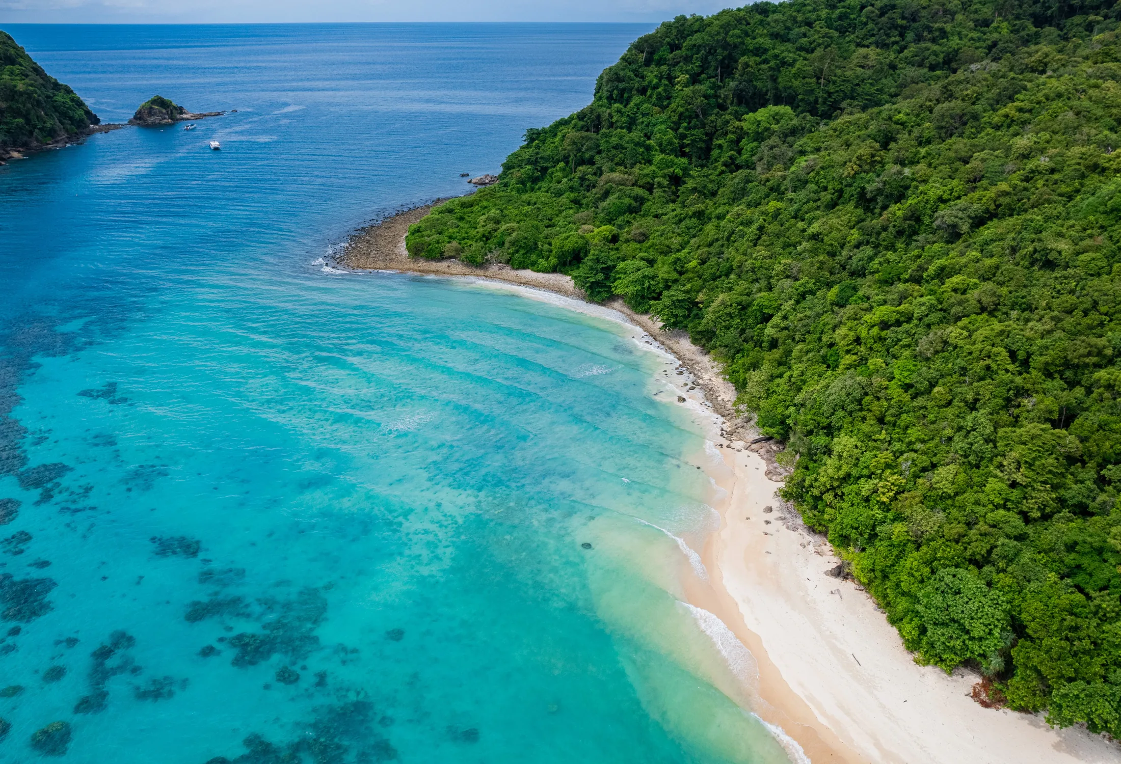 Aerial view of Rok Island's forest, white beach and turquoise reef