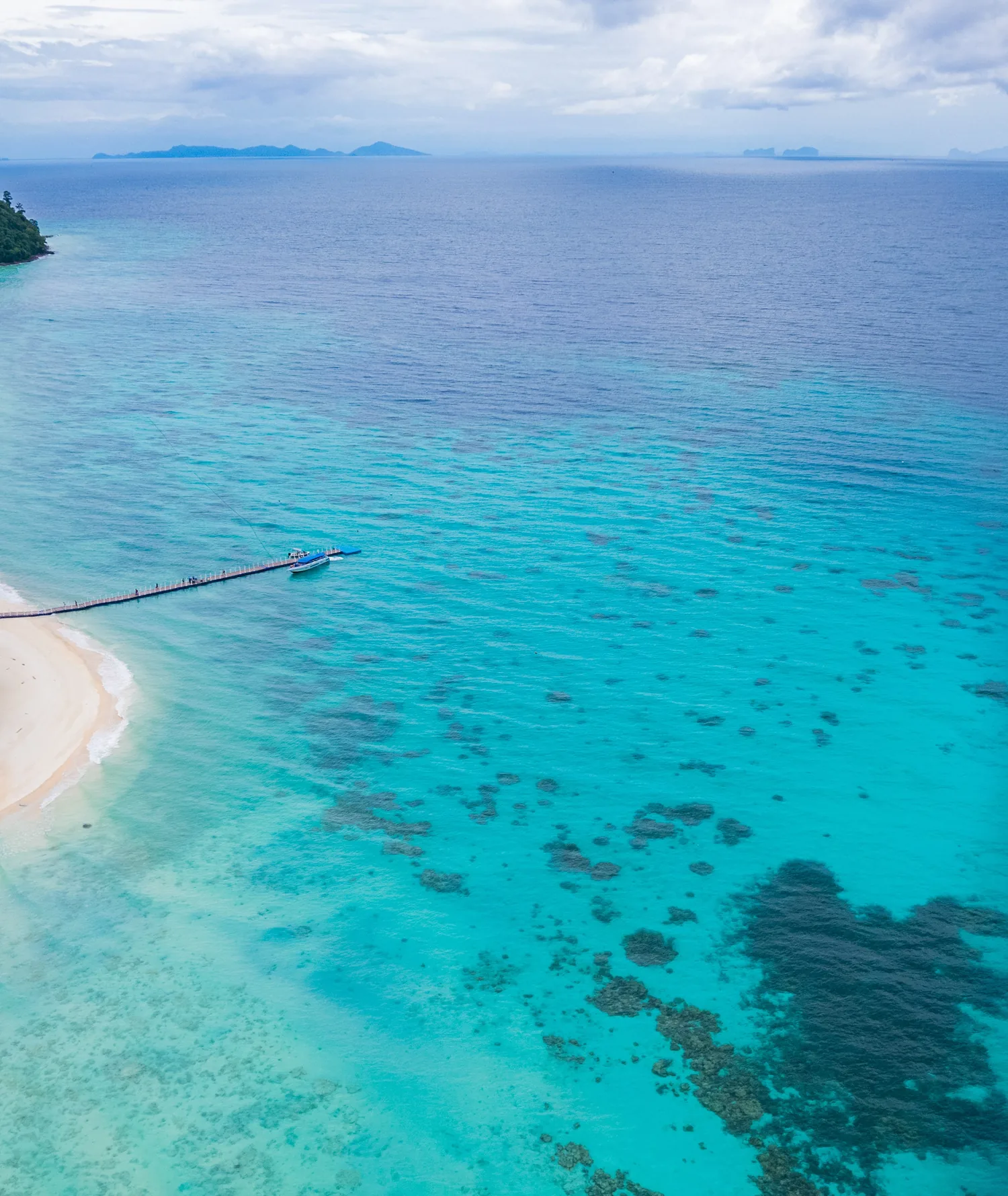 Aerial view of clear reef water and a white beach on Rok Island