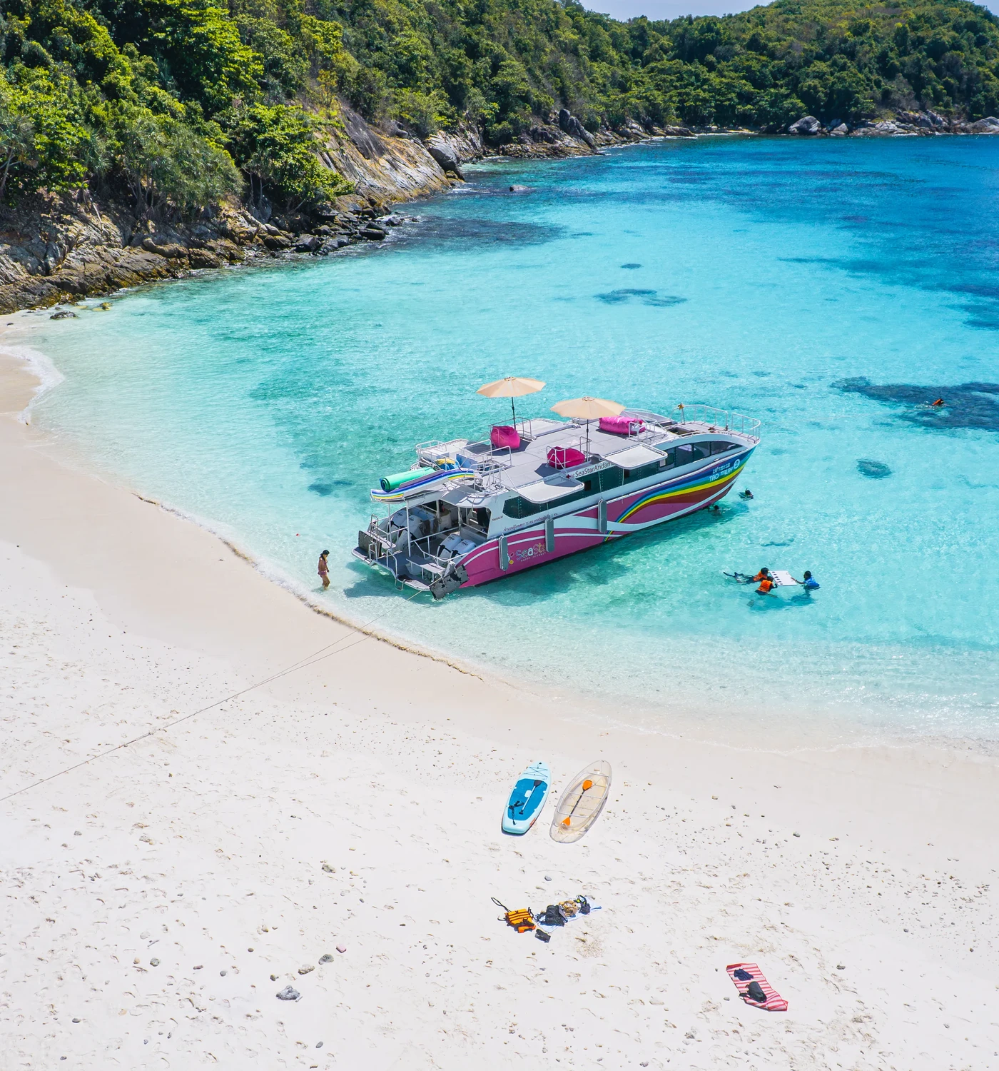 Forested rocky coastline and clear turquoise water near the Racha Islands