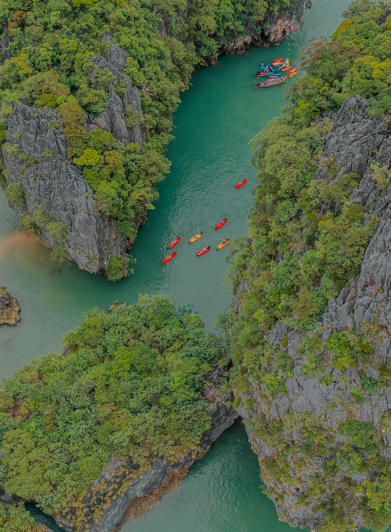Canoes moving between forested limestone islands